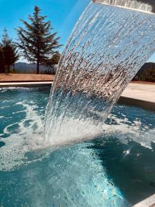 einen Brunnen, der Wasser in einen Pool spritzt in der Unterkunft HOTEL LA CABANA BERGA in Berga