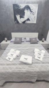 Una cama grande con toallas blancas encima. en Sa Benedica - Luxury House, en Calatabiano