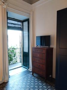 a room with a television and a dresser with a window at BBCasablu in Acireale