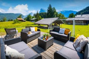 a patio with couches and chairs on a wooden deck at Chalet Pativerdan - OVO Network in Samoëns