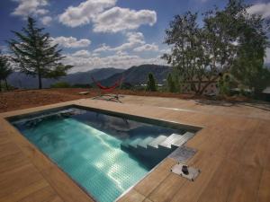 uma piscina com um deque e uma cadeira ao lado em HOTEL LA CABANA BERGA em Berga