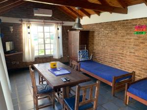 ein Esszimmer mit einem Tisch, Stühlen und einer Ziegelwand in der Unterkunft Altos de la Laguna in Chascomús
