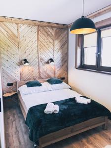 sypialnia z 2 łóżkami i ręcznikami w obiekcie Apartamenty Pod Brzezinami w Murzasichlu