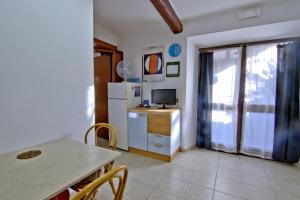 a kitchen with a table and a refrigerator at Villa Very in Marina di Campo