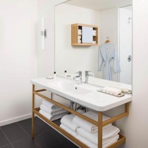 a bathroom with a sink and a mirror and towels at The Study at Johns Hopkins in Baltimore