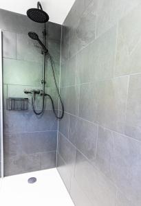 een douche met een douchekop in de badkamer bij Haus Theresia Rüf in Au im Bregenzerwald