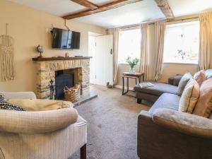 a living room with two couches and a fireplace at Primrose Cottage Stow in Stow on the Wold