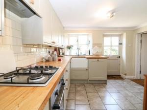a kitchen with white appliances and a stove top oven at Primrose Cottage Stow in Stow on the Wold