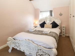 a bedroom with a white bed in a room at Primrose Cottage Stow in Stow on the Wold
