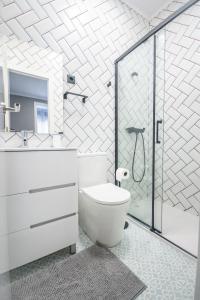 W łazience znajduje się toaleta i przeszklony prysznic. w obiekcie Gran Apartamento 6 SUITES Bilbao Center w mieście Bilbao
