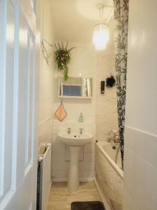 uma casa de banho branca com um lavatório e uma banheira e um lavatório. em EXCELLENT DOUBLE ROOMS IN CHEAP RATE AROUND CENTRAL LONDON em Londres