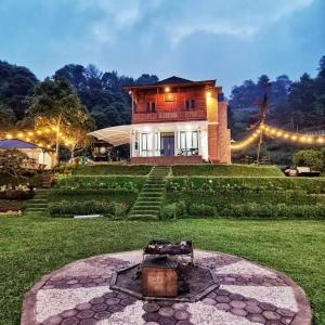 uma casa grande com luzes à frente em Tiris Pisan Glamping & Resort Puncak em Cikuray