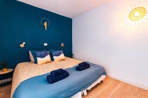 una camera da letto con un letto con due cuscini blu sopra di Canaima Corner with Heated Pool a Mogán