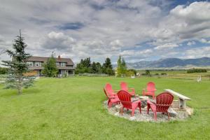 a group of red chairs sitting in a field at Bozeman Home on 11 Acres with Mountain Views! in Bozeman