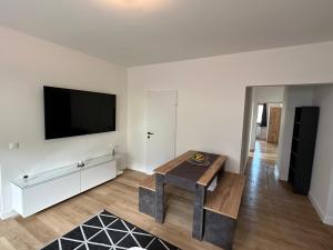 un soggiorno con tavolo e TV a schermo piatto di Apartment Deluxe Rosenheim Top 1 