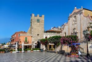a building with a tower with a clock on it at Casa Christine in Taormina