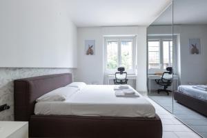 1 dormitorio con 1 cama grande y espejo en San Siro Apartment, en Milán