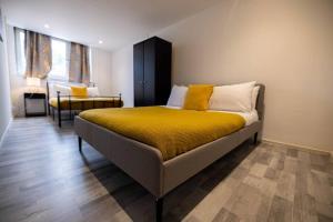 a bedroom with a bed with yellow sheets and a chair at Pristine 3 bed Apartment in London