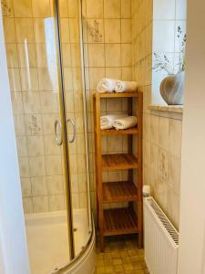 a bathroom with a shower and a shelf with towels at Düne 77 Moderne Ferienwohnung in Baltrum