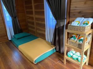 a room with a bed and a shelf with towels at Tiris Pisan Glamping & Resort Puncak in Cikuray
