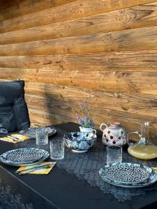 a black table with plates and glasses and a vase at Ferienhaus_natikrausz 
