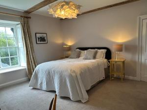 a bedroom with a large bed and a chandelier at The Priory 