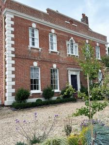 a red brick house with a garden in front of it at The Priory 