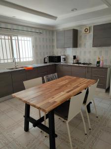 a kitchen with a wooden table and chairs at Eli Ndatis Self Catering Apartments in Kololi