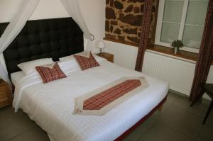 a bedroom with a bed with white sheets and red pillows at Domaine du Haras de Saint Pierre Appartement de 90m2 in Saint-Pierre