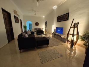 un soggiorno con divano e TV di IKHSHANA NATURE HILLSIDE HOME a Kuah