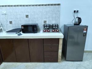 una cucina con forno a microonde e frigorifero di IKHSHANA NATURE HILLSIDE HOME a Kuah