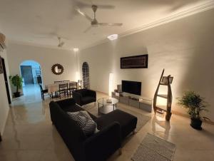 un soggiorno con divano e TV di IKHSHANA NATURE HILLSIDE HOME a Kuah