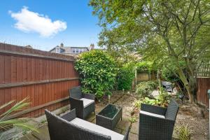 a garden with chairs and a fence at Stunning Central London 2 Bed Parking & Garden in London