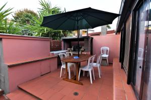 a table and chairs with an umbrella on a patio at Villa Very in Marina di Campo
