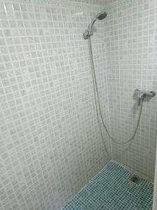 a shower in a bathroom with white tiles at Holiday apartment in Puerto de Sagunto