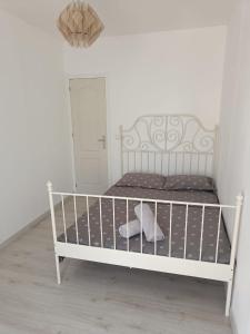 a white bed in a white room with a door at Holiday apartment in Puerto de Sagunto