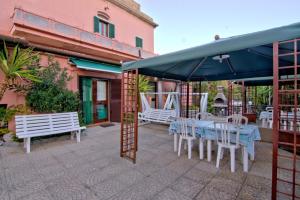 a patio with a table and chairs and an umbrella at Villa Very in Marina di Campo