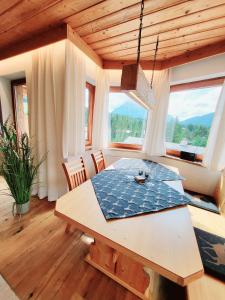 a dining room with a table and some windows at Schickster Sky Lodge in Leutasch