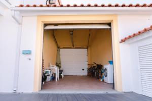 an open garage with a white garage door at Retiro da Atafona Beach Pool House White in Monte +53 photos