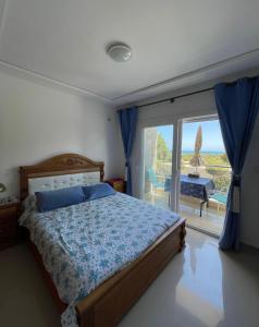 1 dormitorio con 1 cama y puerta corredera de cristal en appartement vue sur mer saidia en Saïdia