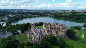 eine Luftansicht eines Schlosses auf einem See in der Unterkunft Central Apartment Linlithgow in Linlithgow