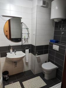 W łazience znajduje się umywalka, toaleta i lustro. w obiekcie Apartment Josip Split w Splicie