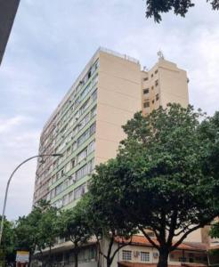 ein hohes Gebäude mit Bäumen davor in der Unterkunft Flat Reformado no centro histórico RJ in Rio de Janeiro