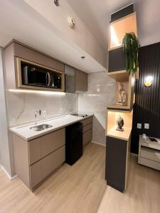 a kitchen with a sink and a microwave at Flat Pleasure in Goiânia