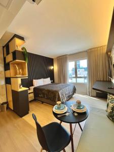 戈亞尼亞的住宿－Flat Pleasure，酒店客房配有一张床铺和一张桌子。