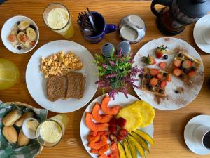 a wooden table with plates of food on it at La Clave Hostel in Cali