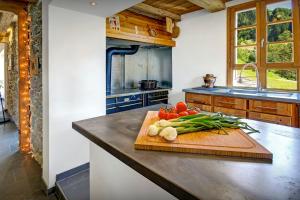 Les Clefs的住宿－Chalet Ladroit - OVO Network，厨房配有带蔬菜的切板,在柜台
