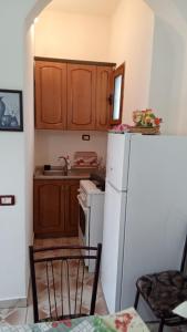 a kitchen with a white refrigerator and wooden cabinets at Home to rent-Casa vacanza-Shtepi pushimesh-KONDAJ in Orikum