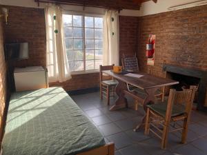 Habitación con mesa, sillas y chimenea. en Altos de la Laguna en Chascomús