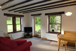 a living room with a red couch and windows at Ashfield House in Pateley Bridge